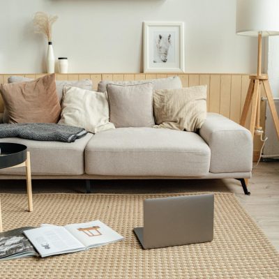 A contemporary living room featuring a sofa, laptop, and modern decor, ideal for remote work.