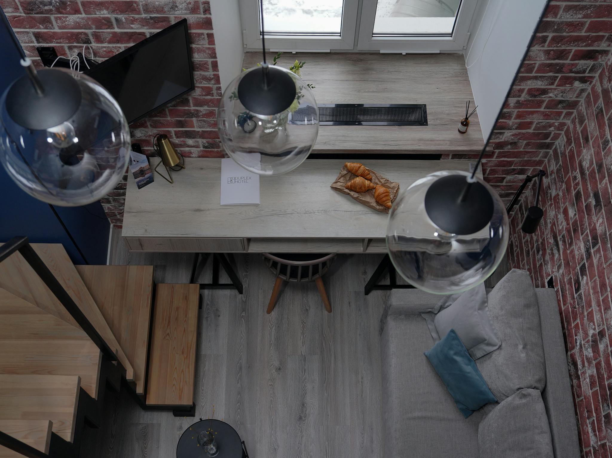 Aerial view of a modern loft featuring croissants and stylish lighting.
