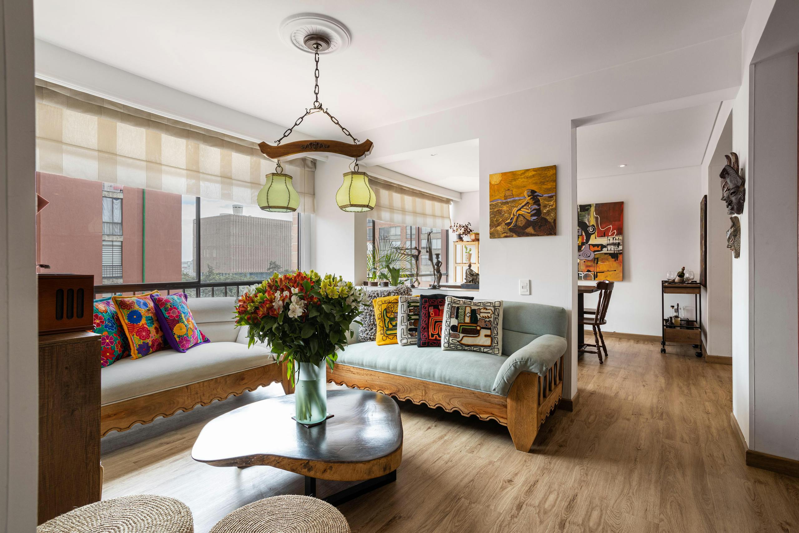 Modern living room with stylish furniture, vibrant cushions, and natural light.